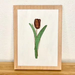 A multi-layer tulip art piece made from colored wood veneers.
