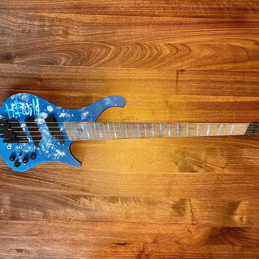 Custom laser cut electric guitar with wood and acrylic layers, LED-backlit frets and name.
